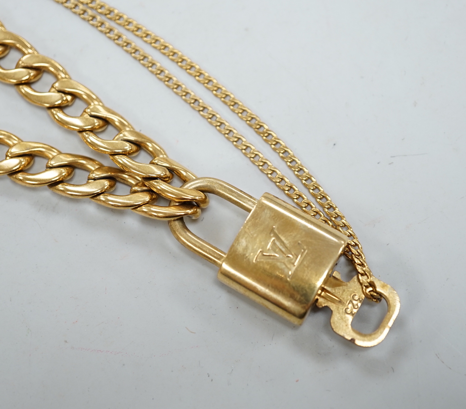 A Louis Vuitton gilt metal key and padlock pendant, 36mm, on a Boutique Secondlife of London, curb link chain, chain 40cm.